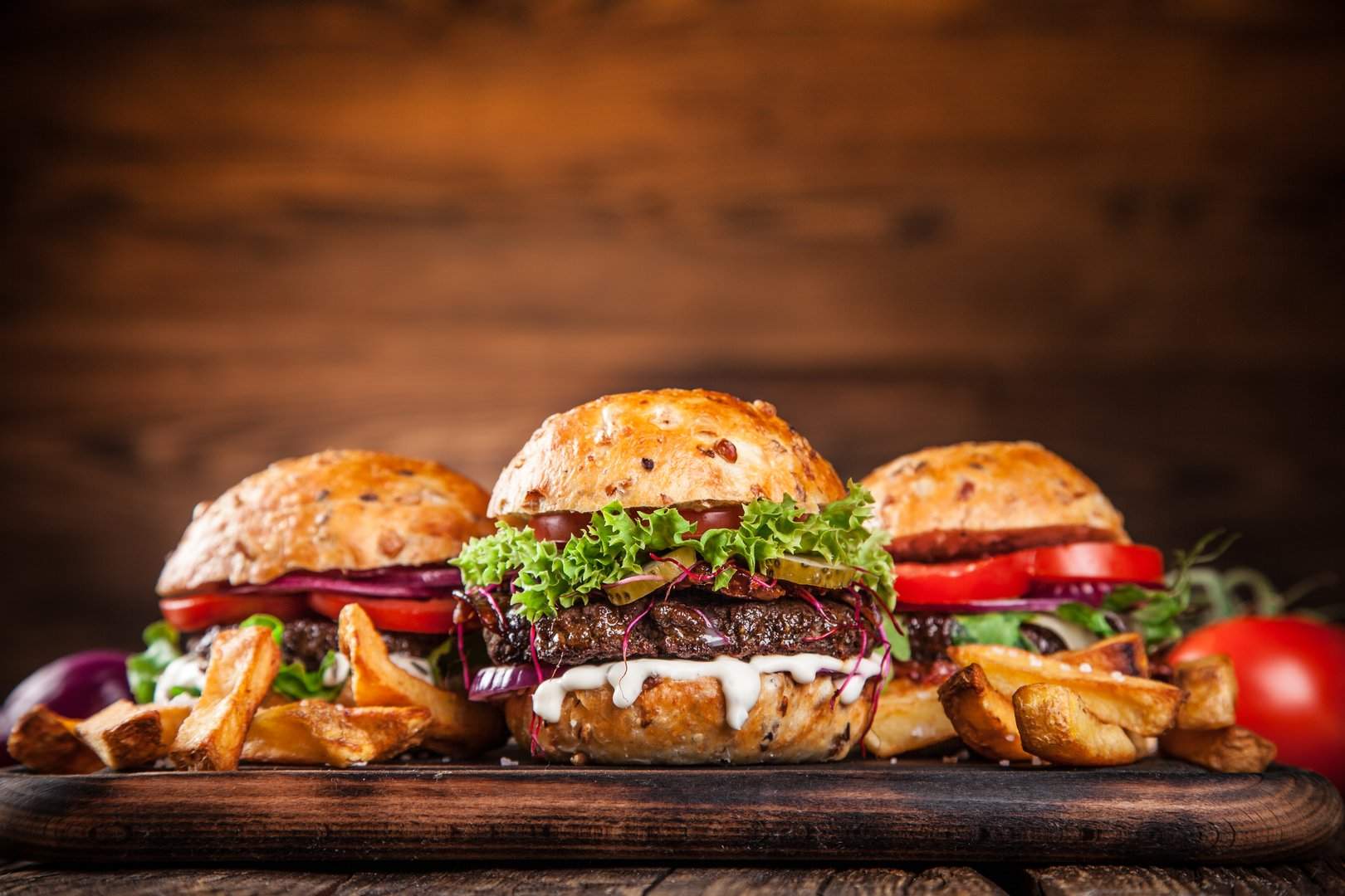 Drei Burger auf einem Holzbrett