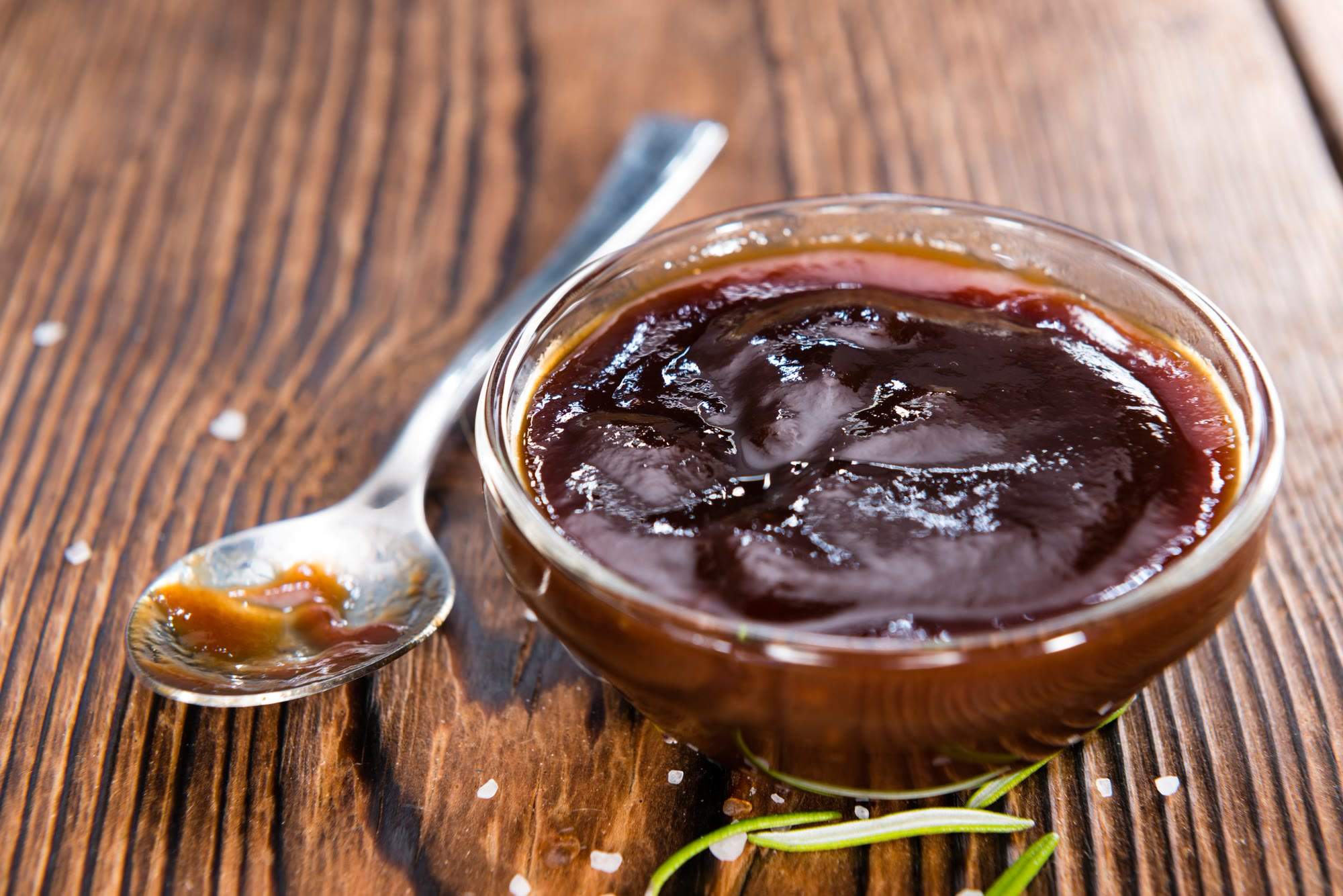 Dunkle BBQ-Sauce in einer Schale auf Holz
