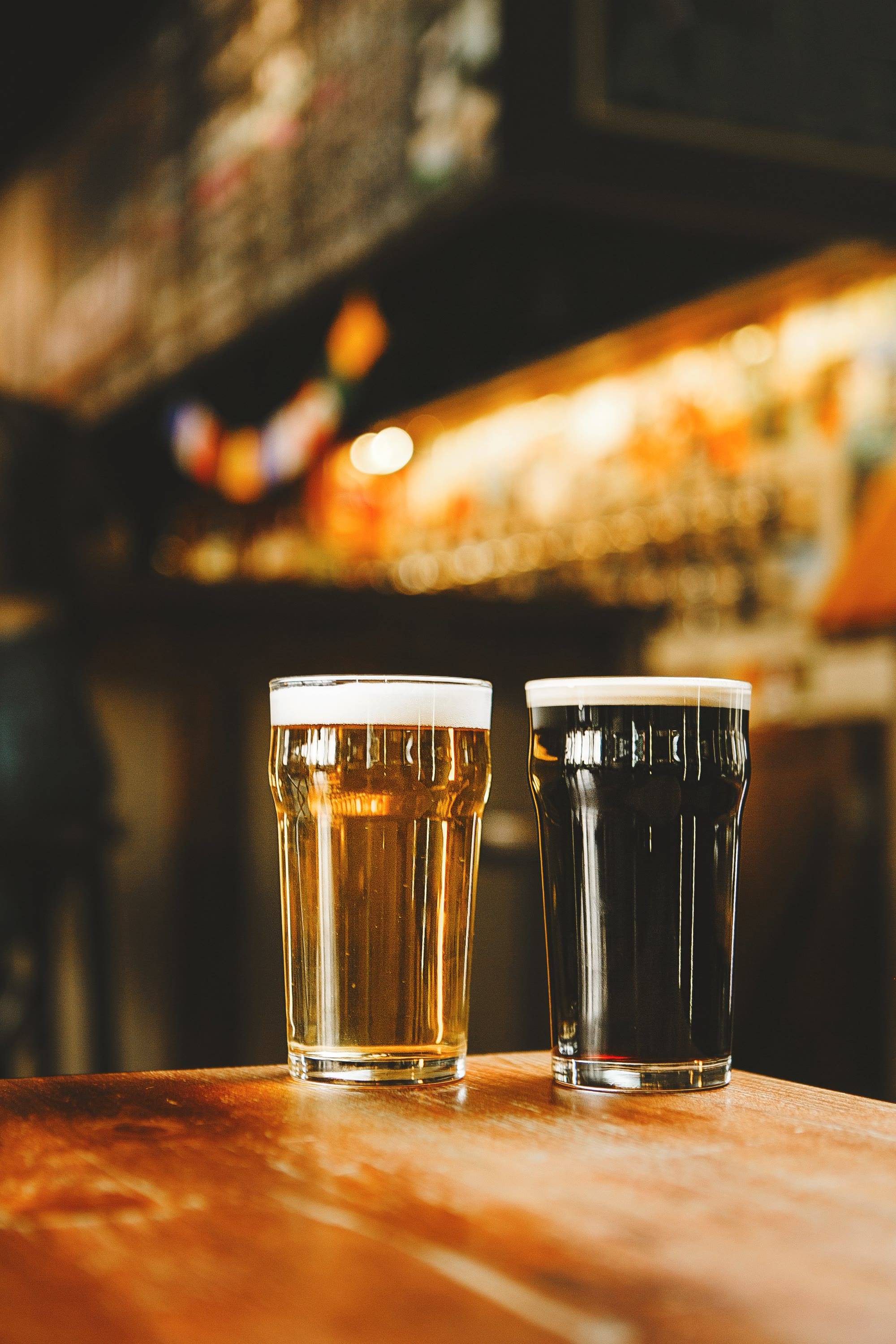 Zwei Gläser Bier auf einem Holztresen